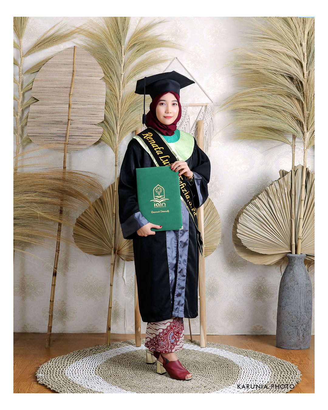 Group of friends in caps and gowns cheering together with arms around each other